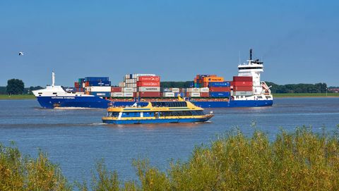 Kleines Containerschiff mit Lühe Schulau Fähre